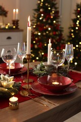 Christmas place setting with festive decor on wooden table in room