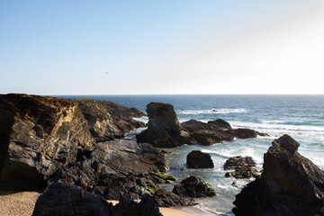 Stunning view of dramatic cliffs and the vast ocean in Porto Covo, Portugal, showcasing the power of nature and the serene beauty of the coastline