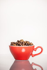 red cup with coffee beans on a light background.