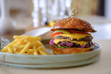 Juicy double cheeseburger with melted cheese served with a side of golden fries