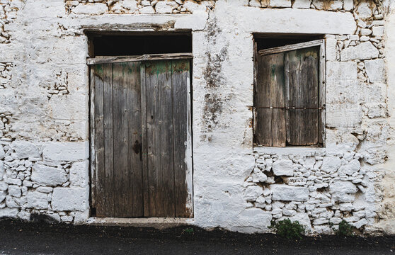 Destroyed white wall of abandoned building with wooden door - Powered by Adobe
