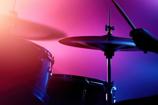 Captivating performance by a drummer under vibrant stage lights during a live concert