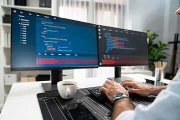 Cropped typing hands photo in smart IT developer working software development coding on two pc...