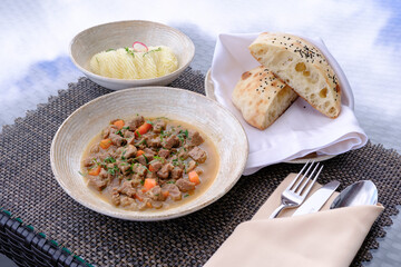 Savory stew with tender meat carrots and herbs served with fluffy mashed potatoes and warm bread