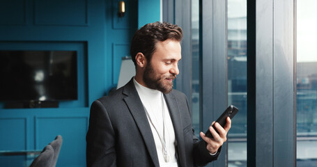 Office, businessman and reading with phone for notification, news and online article for...