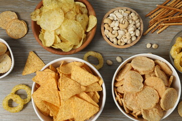 Various unhealthy snacks on wooden background