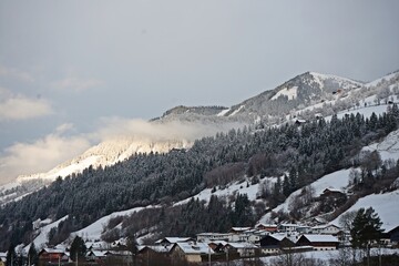 Majestic mountains with snow-covered slopes, illuminated by bright daylight. The clear blue sky...