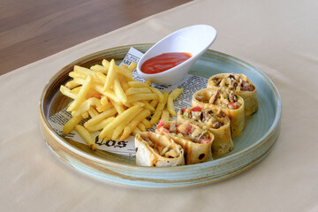 Savory meat wraps served with golden fries and a side of dipping sauce