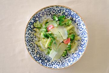 Creamy pasta dish with broccoli cherry tomatoes and parmesan cheese