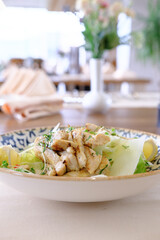 Grilled chicken salad served in a bowl with lettuce and a creamy dressing
