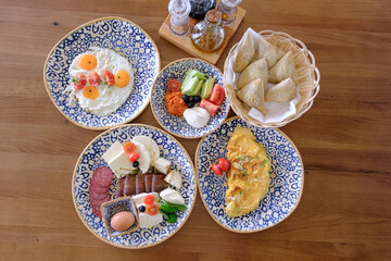 A delicious and healthy breakfast spread featuring eggs cheese pastries and fresh vegetables
