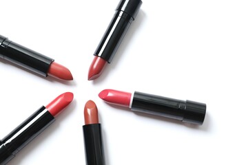 Multi-colored lipsticks are arranged in a circle and isolated on a white background