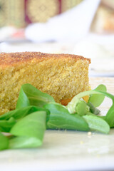 A slice of golden cornbread served alongside fresh vibrant green lettuce