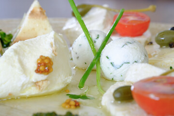 A delectable arrangement of creamy cheese herbs and olives artfully plated for a sophisticated appetizer