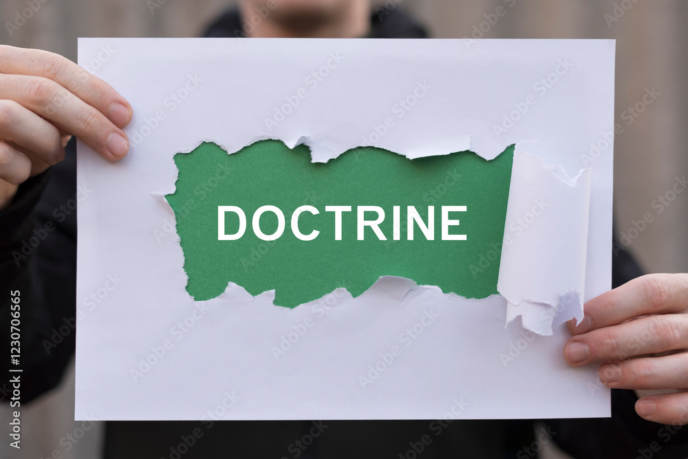 Fototapete man holding composition of sheets of paper with text: doctrine. doctrine business concept. body of t