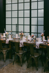 Elegant dining setup in a modern venue with flowers and candles for a special occasion in the evening