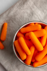 Organic Baby Carrots in a Bowl, top view. Flat lay, overhead, from above. Copy space.