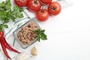 Canned meat in bowl and fresh vegetables on white wooden table, flat lay. Space for text