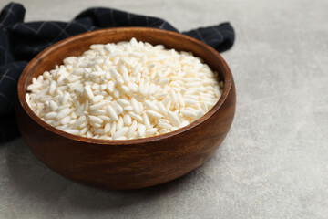 Puffed rice in bowl on light grey table, closeup