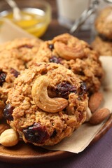 Delicious oatmeal cookies with raisins and nuts on table, closeup