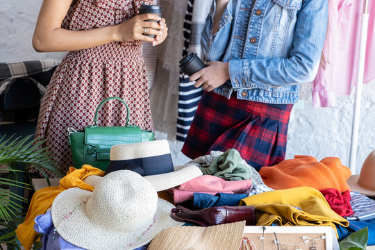 Young women at swap party. Casual clothes, shoes, hats, bags, jewellery. Idea of exchange your old wardrobe for new. Eco friendly cloth concept. Zero waste shopping, reduce and reuse, donation