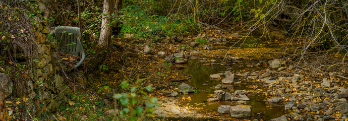 Plastic chair, rubbish and waste in the clean mountain rivers.