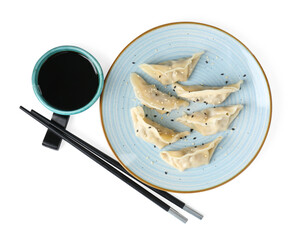 Tasty gyoza (dumplings), soy sauce and chopsticks isolated on white, top view