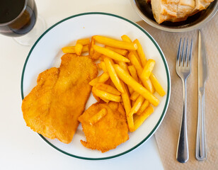 Delicious breaded chicken breast cutlet with french fries