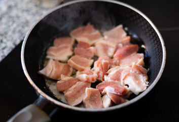 Raw pork meat in a frying pan, food preparation