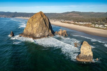 Coastal Oregon: Haystack Rock and the beach below. Waves crash against the iconic rock formation,...