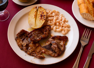 Delicious appetizing fried lamb ribs with boiled potatoes and beans