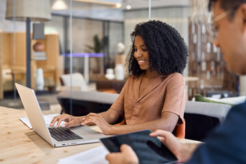 Two busy happy business team people man and woman using laptop computer and tablet working on...