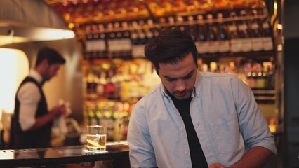 Profile closeup of smiling smart man in white shirt drinking cocktail in Old fashioned of special party beverage vibrant at nightclub on Friday meeting night time at luxurious counter bar. Vinosity.