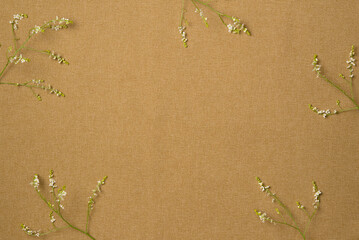 Frame of flowers on fabric background. Flat lay, top view. Copy space