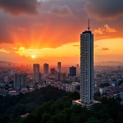 Plakat City skyline at dusk with tall modern building on hill. Urban landscape with business buildings, high rises, beautiful orange sunset sky. Panoramic view from hilltop offers vibrant colors. Strong