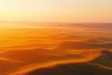Naklejka premium Sunrise paints rolling agricultural fields in warm, golden hues, creating a breathtaking landscape.
