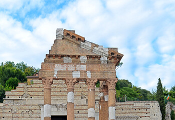 Detail of the Capitolium of Brixia or the Temple of the Capitoline Triad, a UNESCO World Heritage Site in Brescia, Italy with blue sky and white clouds on a summer day