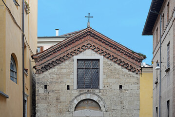 Front gable of the church of San Marco Evangelista (Saint Mark the Evangelist) in roman style with blue sky in Brescia, Italy