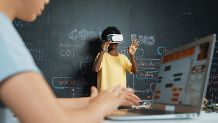 Closeup of school girl hand coding program while african student using VR interact with metaworld....