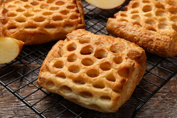 Delicious puff pastries with fruit filling on wooden table, closeup