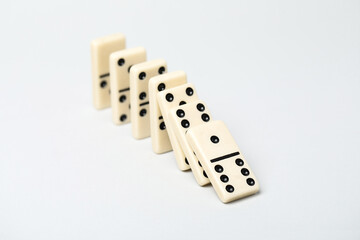 Domino effect. Tiles falling on light background