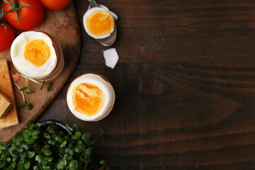 Soft boiled eggs on wooden table, flat lay. Space for text