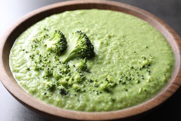 Delicious broccoli cream soup in bowl on grey table, closeup