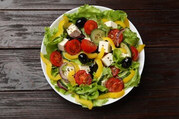 Delicious fresh Greek salad on wooden table, top view