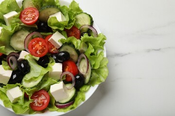 Delicious fresh Greek salad on white marble table, top view. Space for text