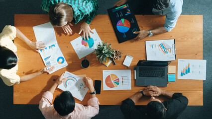 Top view of project manager using tablet to analyze data and financial chart while marketing team...