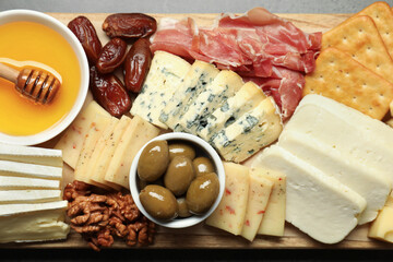 Different types of delicious cheese and other snacks on table, top view