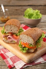 Delicious sandwiches with ham on wooden table, closeup