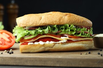 Delicious baguette sandwich with salami and cheese on table, closeup