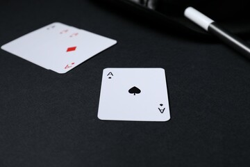 Playing cards, hat and magic wand on black background, closeup